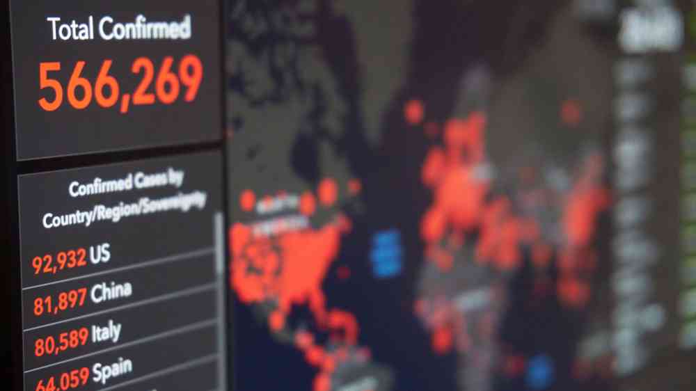 Screen displaying real-time COVID-19 case data with global map and statistics.