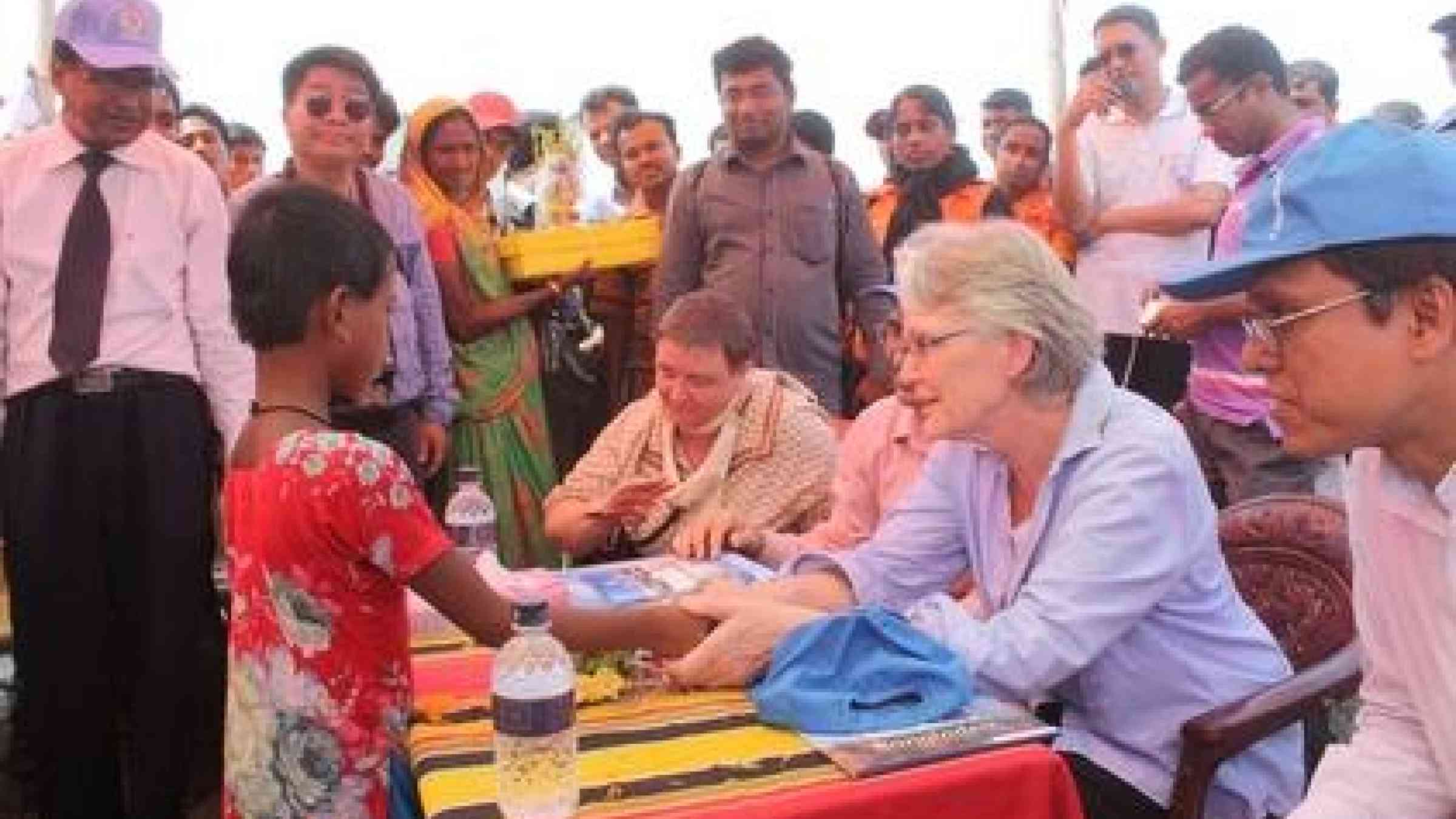 Margareta Wahlström, UNISDR Chief and Special Representative of the Secretary-General for Disaster Risk Reduction, shakes the hand of a child in Bainpara, Bangladesh