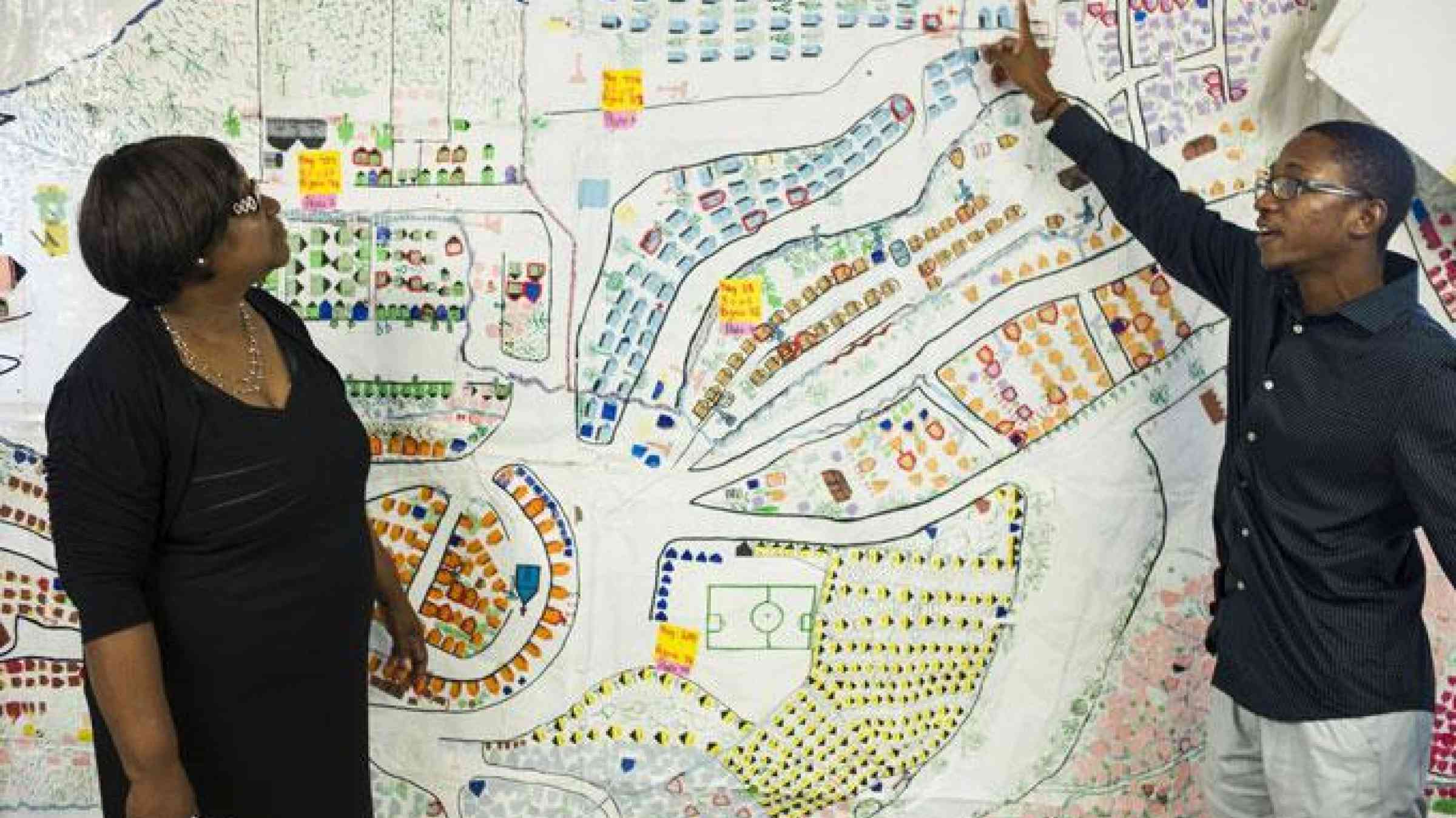 Marie Alta Jean-Baptiste and her colleague Ralph Emmanuel explain the community-led creation of this map of the Caradeux community. Photo: Anna Fawcus / Oxfam America