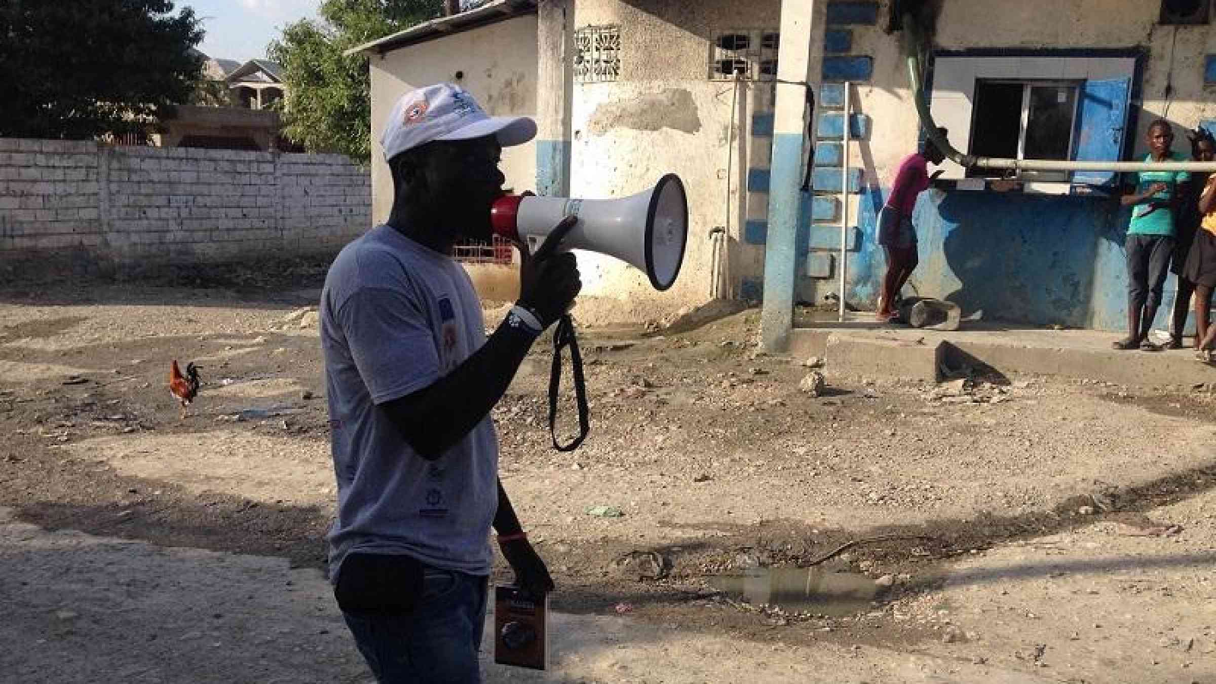 Man speaking in a megaphone. Photo: COOPI