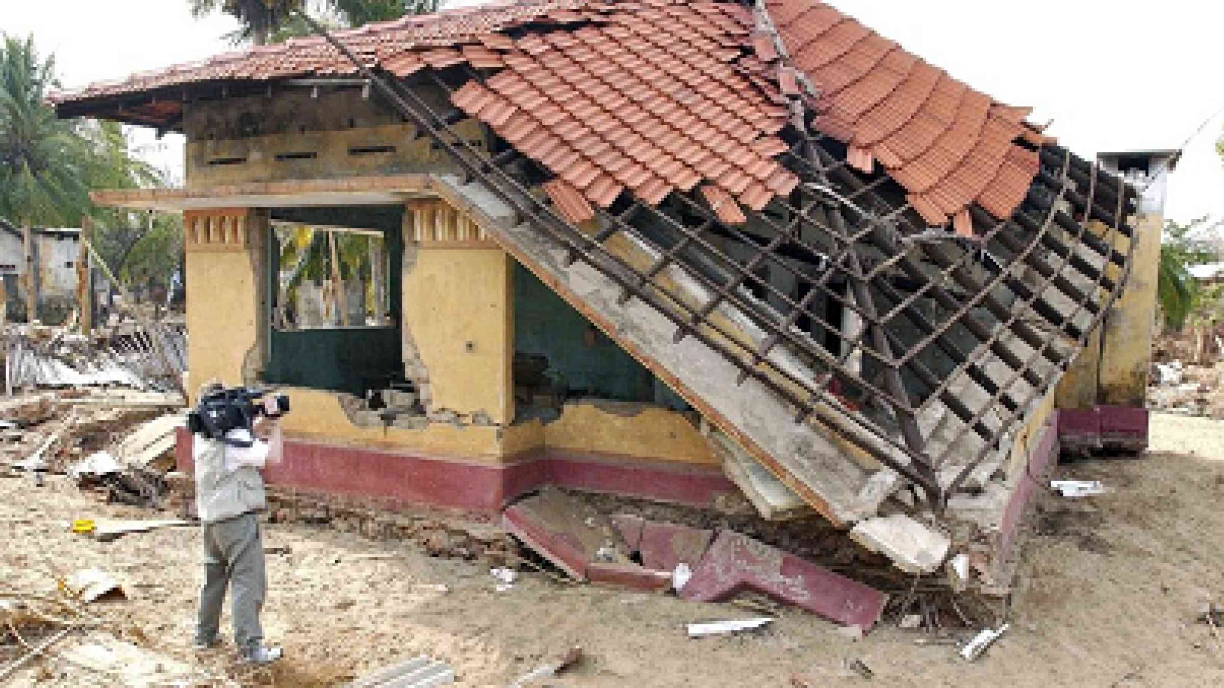 A cameraman films some of the destruction caused by the tsunami of 26 December 2004 in Mullaitivu, a town in northeastern Sri Lanka. The tsunami claimed the lives of thousands of members of this community (UN Photo/Evan Schneider)